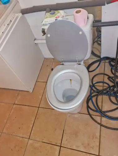 Nettoyage d'un WC par un tuyau d'eau